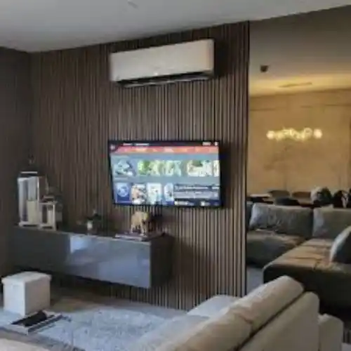 Sala moderna con lambrin PVC decorativo en pared, color gris claro, instalado en residencia de Puebla.