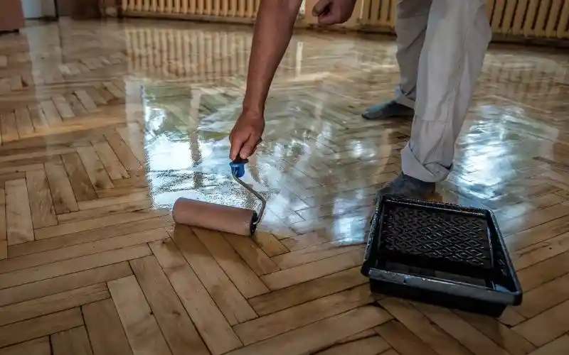 Proceso de pulido y barnizado de piso de madera en una oficina en Puebla, restaurando su brillo original.