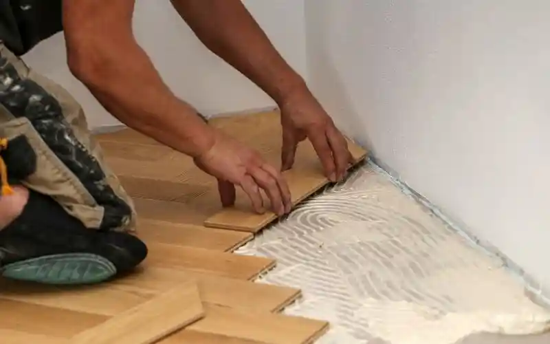 Equipo de Grupo Orvi instalando piso de madera maciza en una residencia en Puebla con herramientas especializadas.