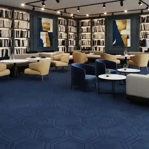 Elegante salón de un hotel o biblioteca con una alfombra modular de diseño en color azul profundo con patrones hexagonales, demostrando una solución de lujo de Grupo Orvi para el sector de la hospitalidad en Puebla.