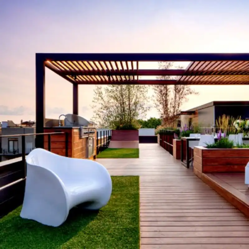 Diseño de roof garden moderno con pasto sintético de 20mm-25mm, combinado con tarima de madera, una silla blanca de diseño y una zona de asador, demostrando la transformación de una azotea en un espacio funcional y estético.