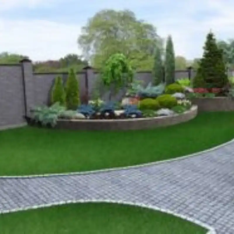 Instalación de pasto sintético modelo Fresco Duo de 40mm en el jardín frontal de una residencia en Zavaleta, con un camino de adoquín curvo y una rotonda de jardinería, ofreciendo un aspecto premium y realista sin necesidad de riego ni poda.