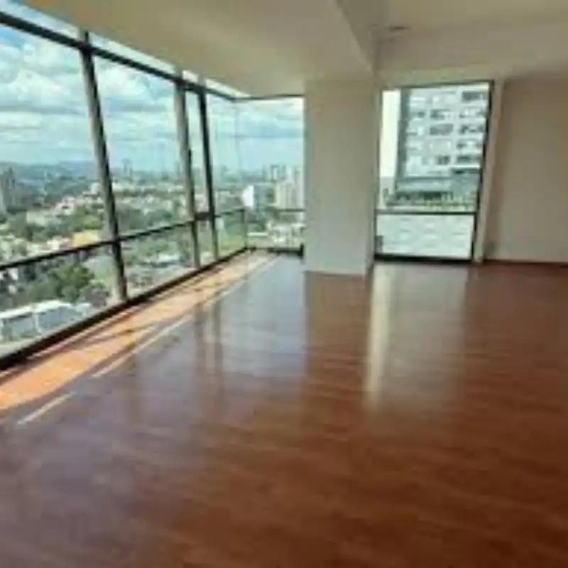 Duela de Nogal Americano en Penthouse de Lujo Interior de un penthouse en La Vista Country Club con duela de nogal americano de acabado brillante. El piso de madera de ingeniería resalta el espacio con ventanales panorámicos en Puebla.