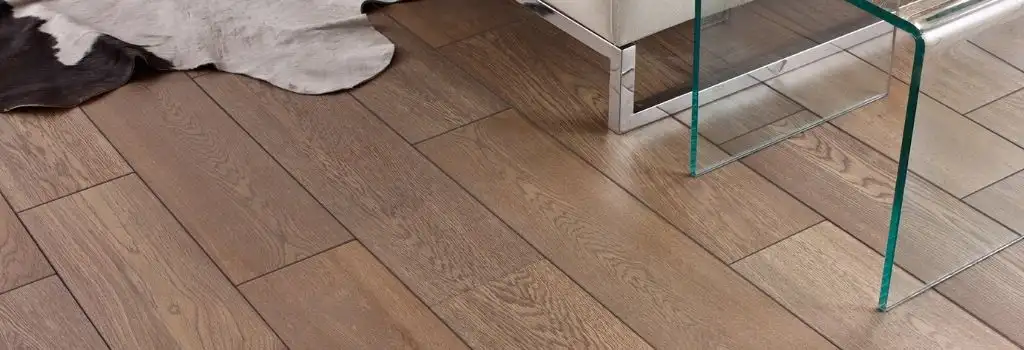 piso-madera-ingenieria-duela-instalacion-puebla Primer plano de duela de madera de ingeniería de tono marrón claro con vetas visibles. El piso está instalado en un espacio interior de lujo, destacando su estabilidad y durabilidad.